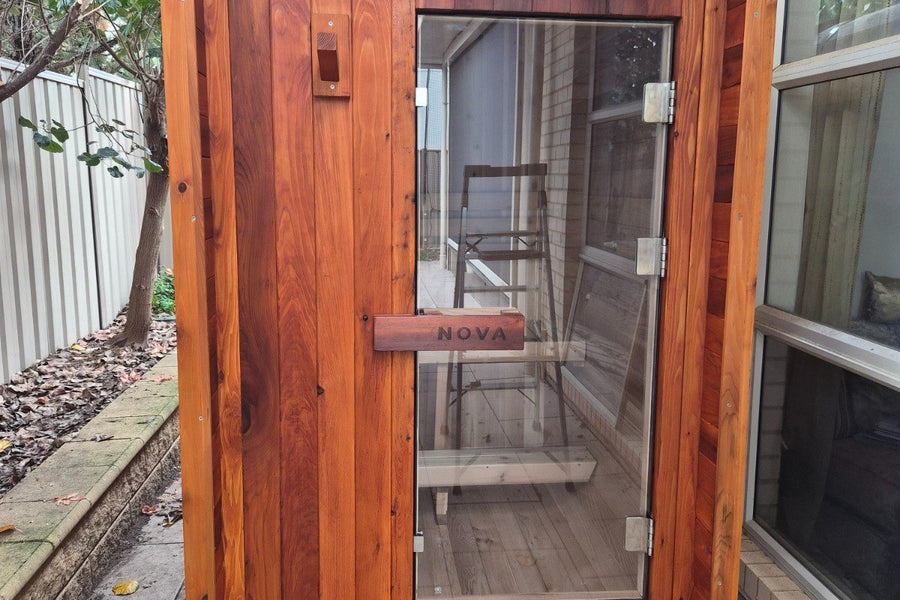 Nova Sauna Lite outdoor sauna with rich timber colour beside a home